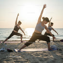 Women Practicing Yoga on the Beach at Sunset