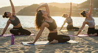 Women Practicing Yoga on the Beach at Sunset