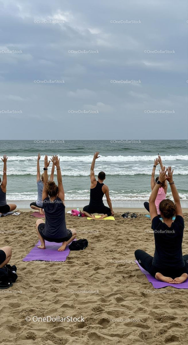Group Yoga Session on a Sandy Beach with Ocean View