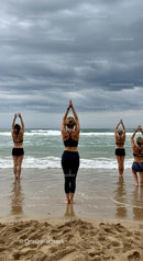 Women Practicing Yoga on a Cloudy Beach
