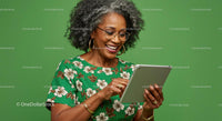 Mature Woman Enjoying Tablet in Green Floral Dress