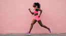 Athletic Woman Running in Pink Sportswear by Pink Wall