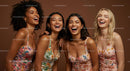 Joyful Women in Colorful Floral Dresses Laughing Together