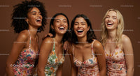 Joyful Women in Colorful Floral Dresses Laughing Together