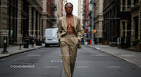Confident Woman in Beige Suit Walking Through City Street