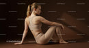 Woman Meditating in Brown Outfit on Yoga Mat