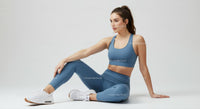 Woman in Blue Athletic Wear Sitting on White Surface