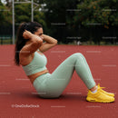 Woman Doing Sit-Ups on Track in Green Athletic Outfit