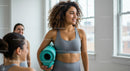 Women Smiling with Yoga Mat in Bright Fitness Studio