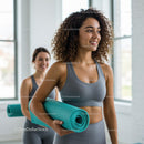 Two Women in Yoga Class Holding Mats in Bright Studio