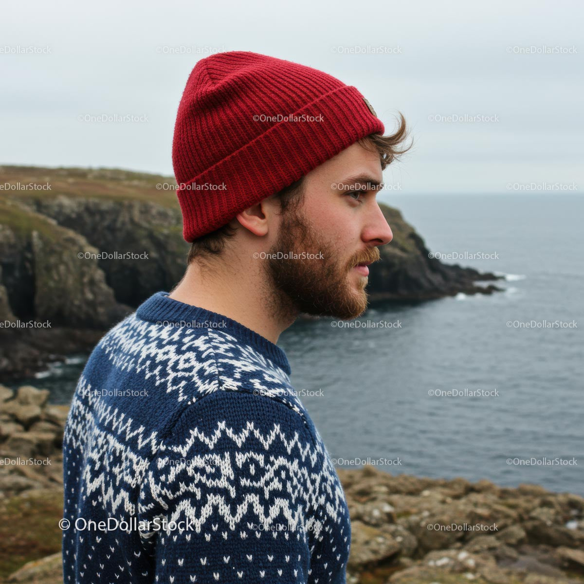 Man in Red Beanie on Scenic Coastal Cliff