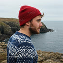 Man in Red Beanie on Scenic Coastal Cliff