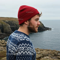 Man in Red Beanie on Scenic Coastal Cliff