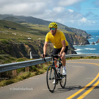 Cyclist on Scenic Coastal Road with Ocean View