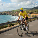 Cyclist in Yellow Riding Along Scenic Coastal Route
