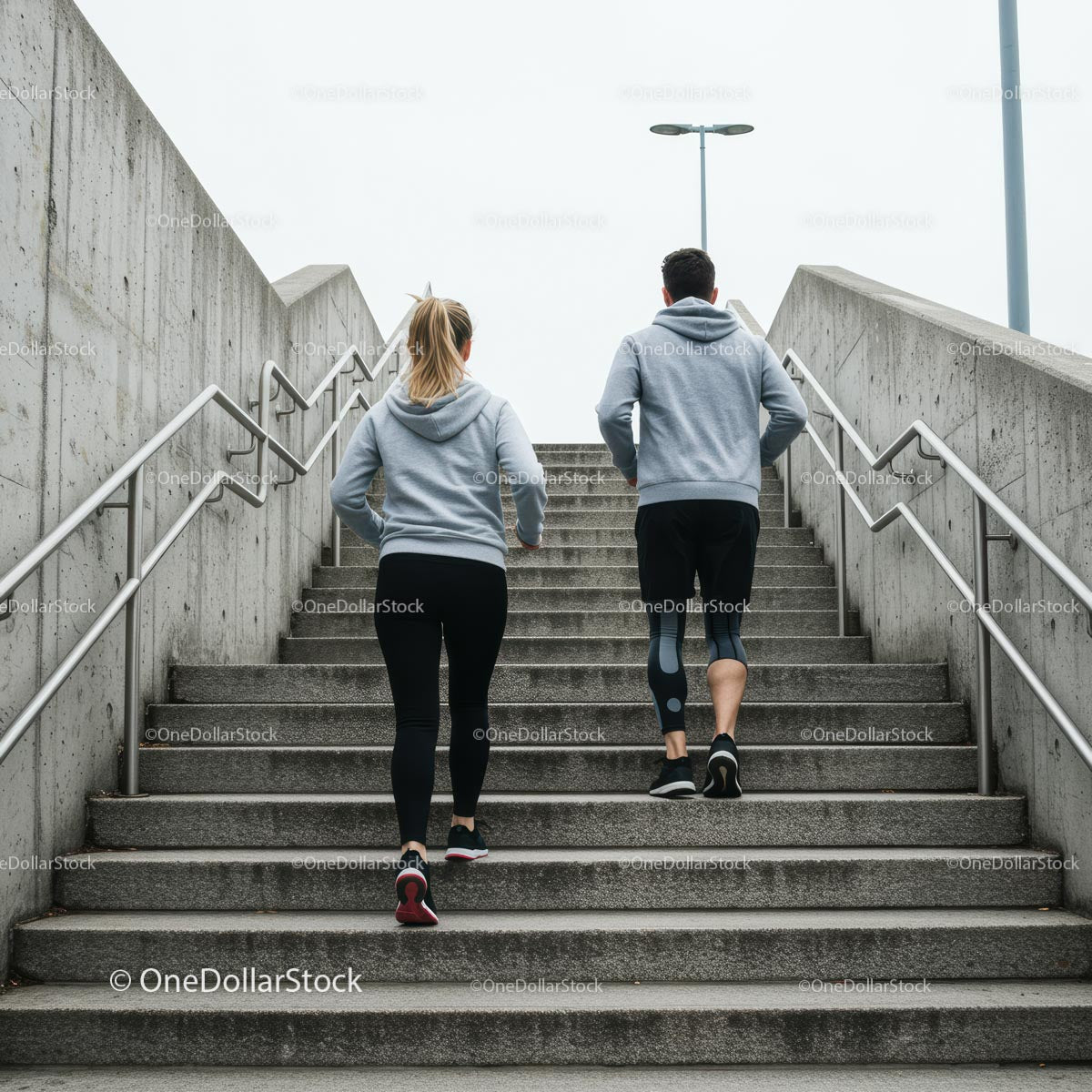 Active Couple Running Up Concrete Stairs in Urban Setting