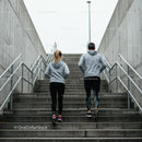 Couple Running Upstairs in Urban Setting