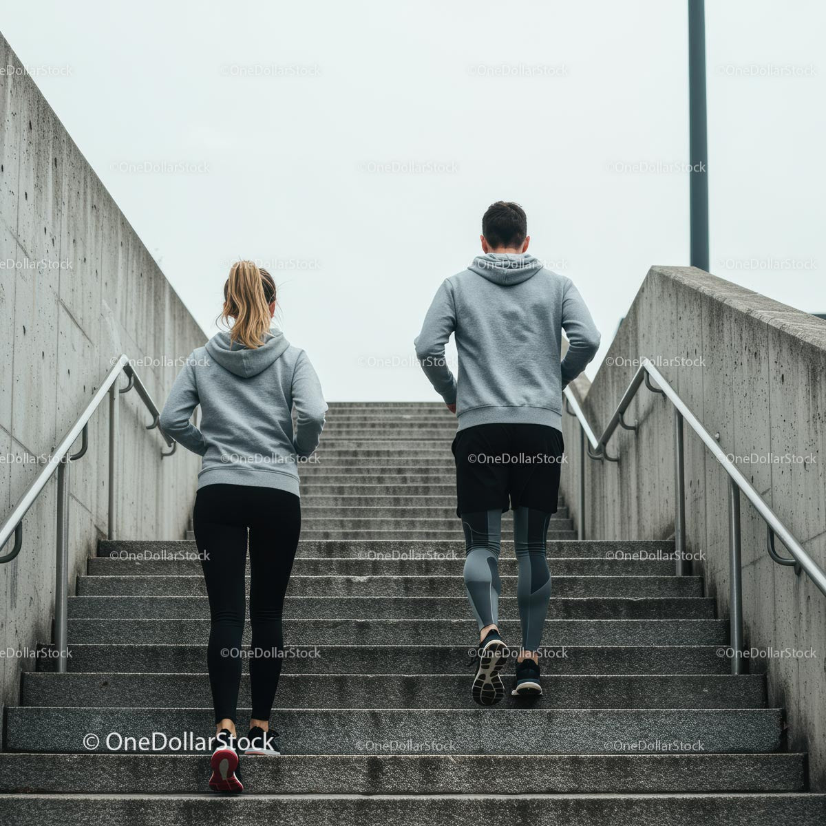 Couple Jogging Up Concrete Stairs in Urban Setting