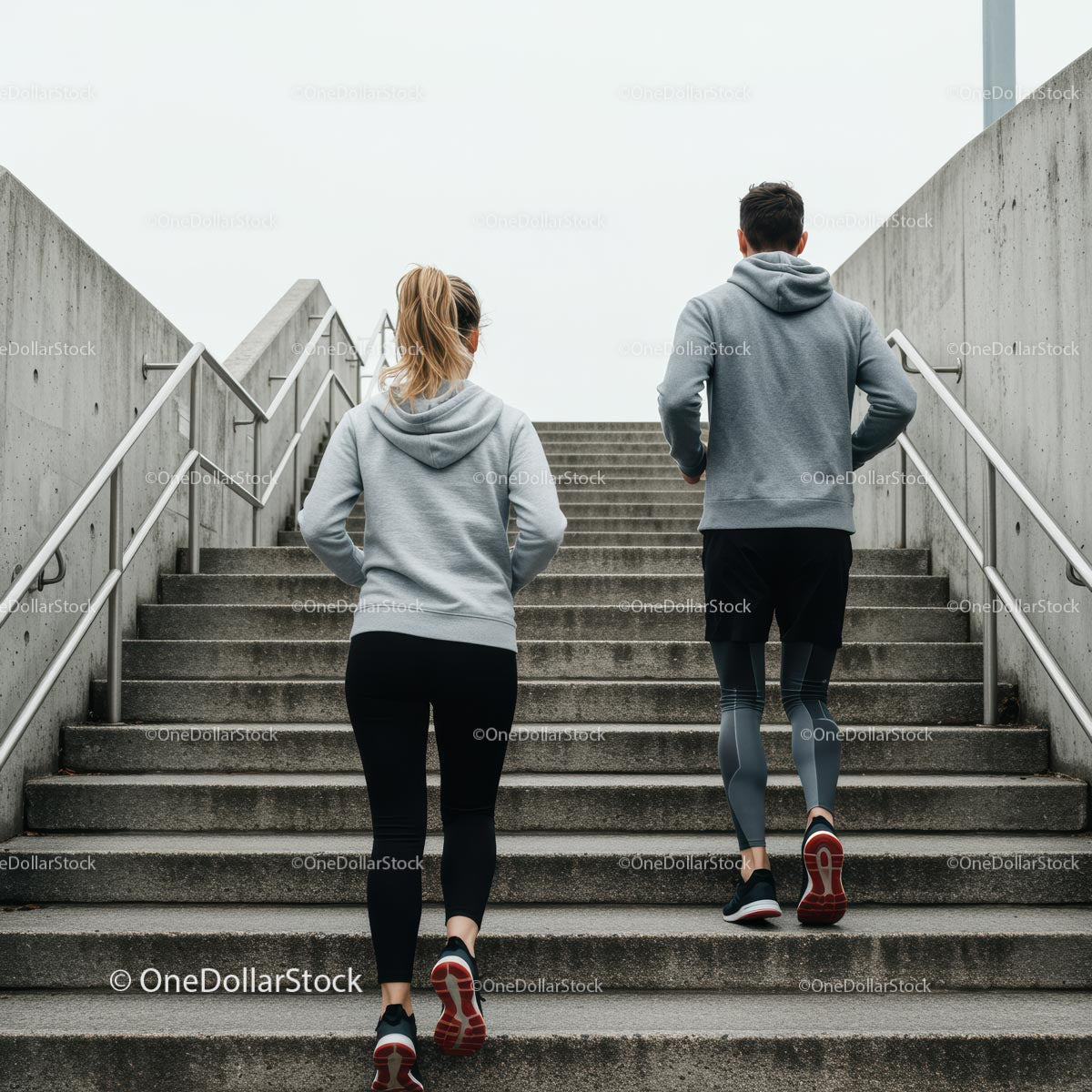Active Couple Jogging Up Concrete Stairs in Urban Setting