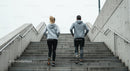 Couple Running Up Concrete Stairs in Urban Setting