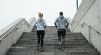 Couple Running Up Concrete Stairs in Urban Setting