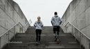 Couple Running Up Concrete Stairs for Fitness Workout