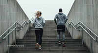 Fit Couple Jogging Up Concrete Stairs in Urban Setting