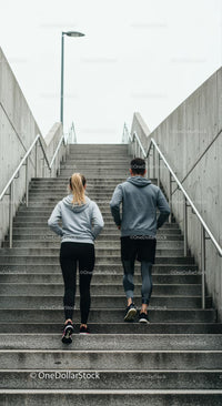 Couple Running on Urban Stairs in Athletic Clothing