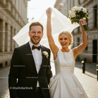 Joyful Bride and Groom Celebrating in Sunlit City Street