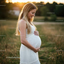 Expectant Mother in White Dress at Sunset in Nature