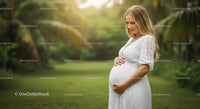 Expecting Mother in White Dress Amidst Lush Greenery