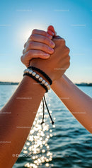Hands Holding with Sunlit Sparkles on Water