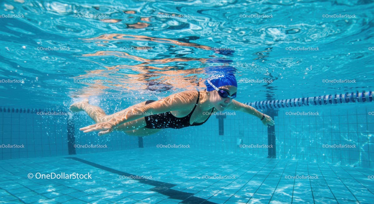 Female Swimmer Gliding Through Clear Blue Pool Water