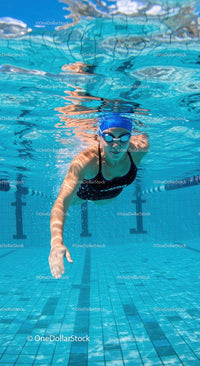 Swimmer Gliding Underwater in a Blue Pool