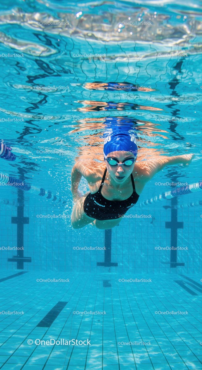 Competitive Swimmer Training Underwater in Blue Pool