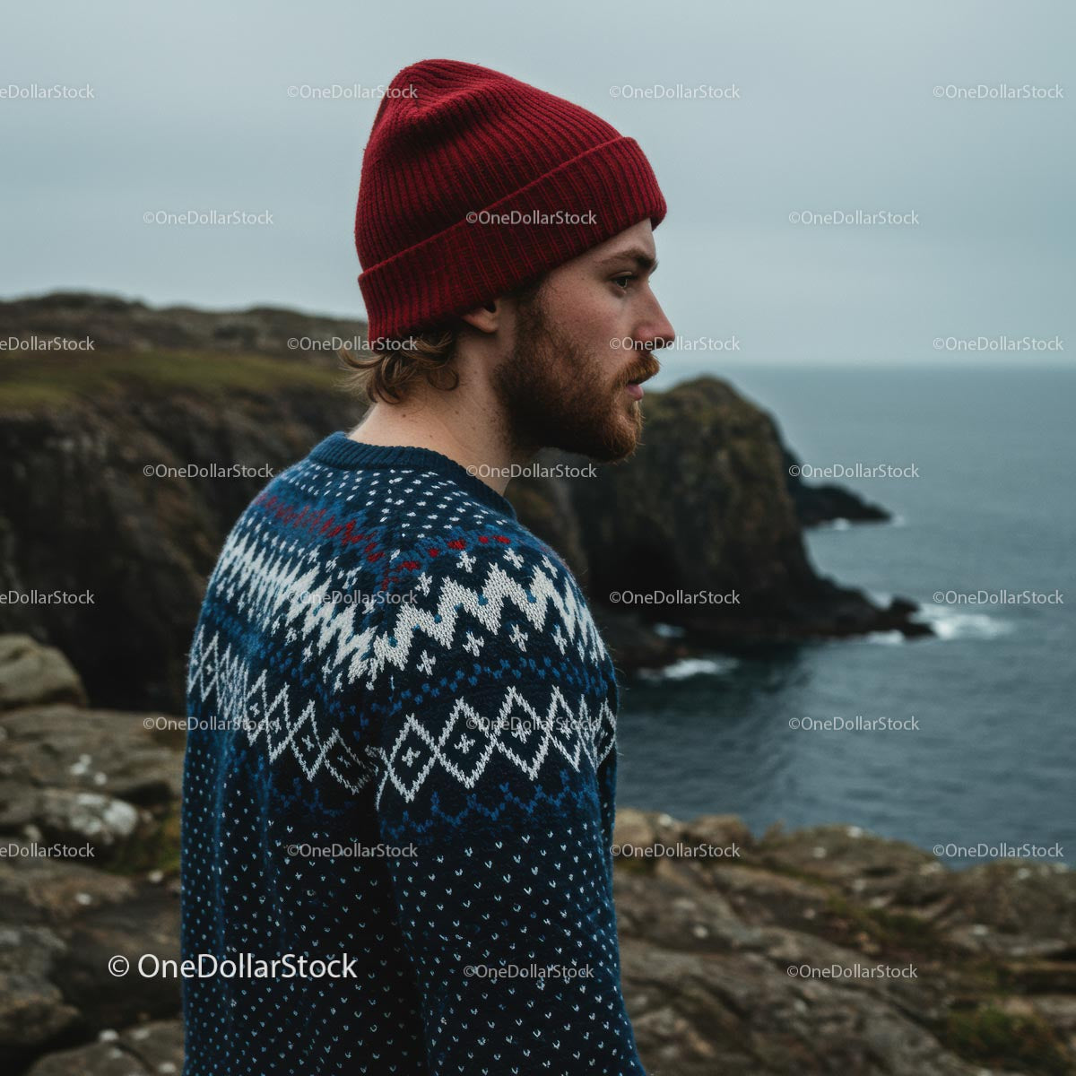 Man in Cozy Sweater Overlooking Rugged Coastline