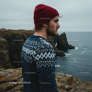 Young Man in Knit Sweater by Rugged Coastal Cliffs