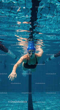 Female Swimmer Gliding Underwater in a Clear Blue Pool