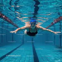 Female Swimmer Gliding Underwater in Swimming Pool