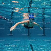 Female Swimmer Gliding Underwater in Blue Pool