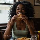 Joyful Woman Savoring a Delicious Burger Indoors
