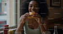 Joyful Woman Savoring a Delicious Burger Indoors