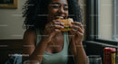 Joyful Woman Savoring a Delicious Burger Indoors
