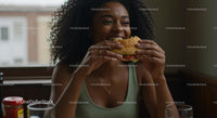 Joyful Woman Savoring a Delicious Burger Indoors