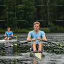 Focused Young Man Rowing on a Calm Lake in Summer