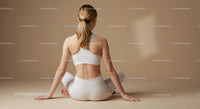 Woman Practicing Yoga in White Outfit on Beige Background