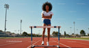 Young Athlete Standing Confidently by Hurdle on Track