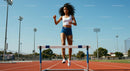 Female Athlete Hurdling on a Sunny Day Track