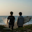 Young Surfers Watching the Ocean at Sunset