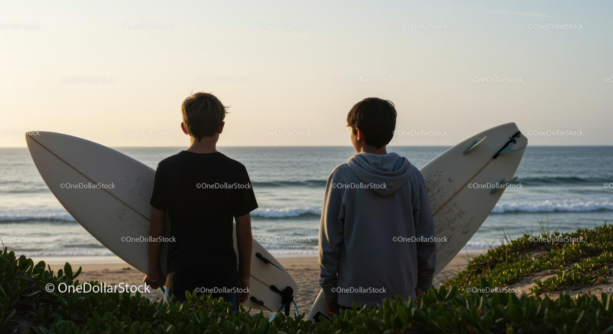 Young Surfers at Ocean Sunset with Surfboards